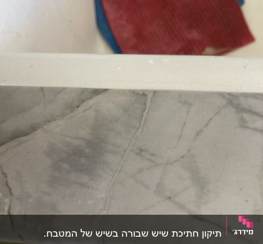 משטח שיש עם סדקים על רקע שטיח אדום